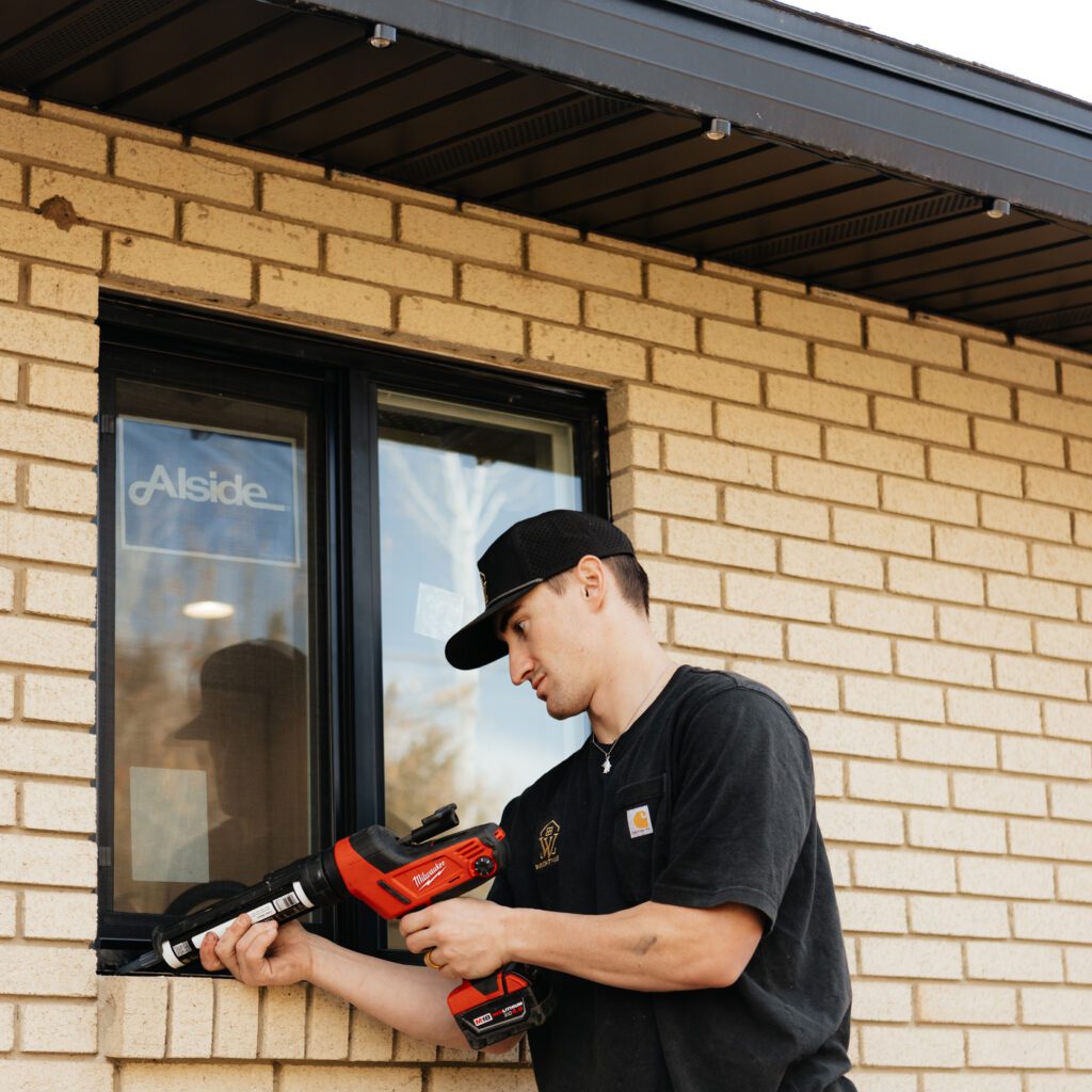 A man is installing a window, showcasing JDI Windows' craftsmanship and attention to detail.