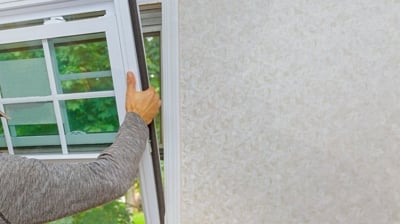 A man installs a window in a house, showcasing JDI Windows' craftsmanship and attention to detail.