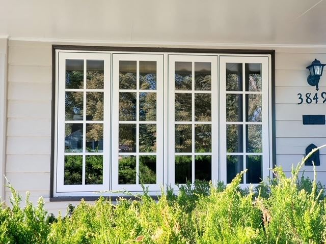 A house with a white window and a sign on the front door reading "JDI Windows."