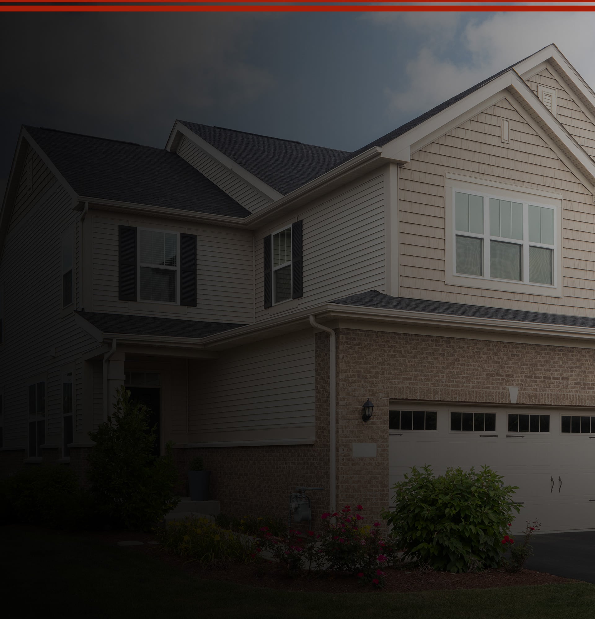 A house with a garage and driveway, featuring JDI Windows prominently displayed on the exterior.