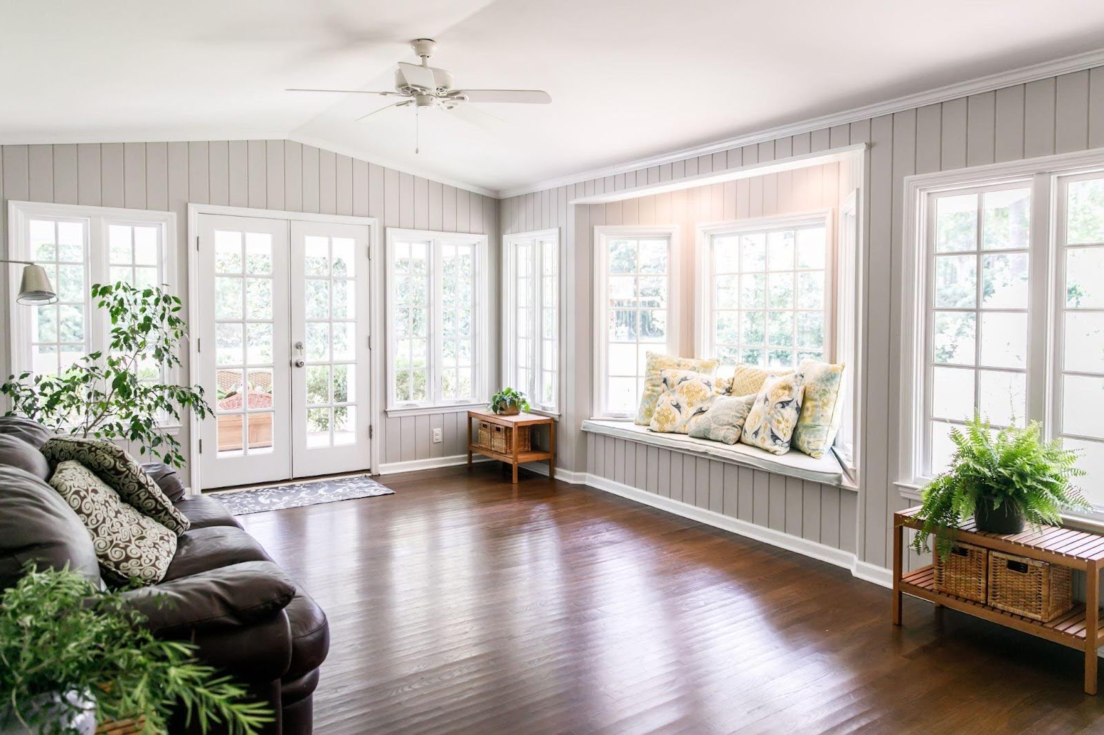 A sunroom with elegant hardwood floors and crisp white walls offering a warm and airy environment