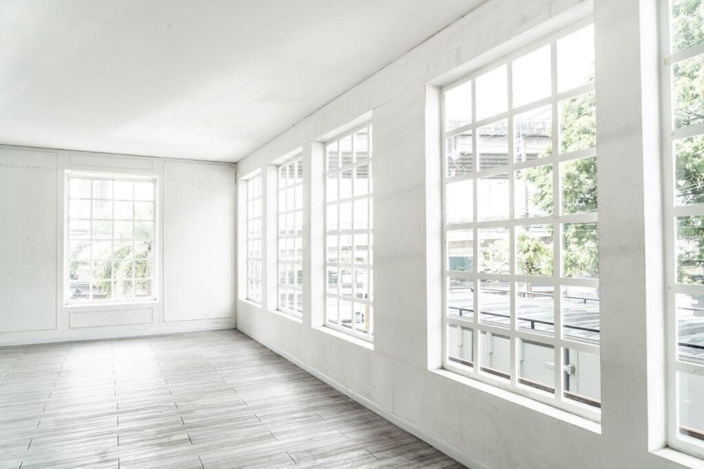Empty room featuring white walls and wooden floors creating a bright and spacious atmosphere
